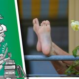 Nackte Füße hängen über Balkon-Balustrade.