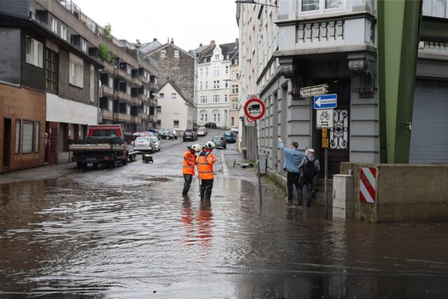 Eine Straße steht unter Wasser. Starker Regen hat am Dienstag in Wuppertal nach Angaben der Feuerwehr zu vollgelaufenen Kellern und überschwemmten Straßen geführt.
