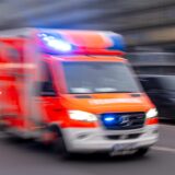 Ein Rettungswagen der Feuerwehr fährt mit Blaulicht zum Einsatz (Aufnahme mit Langzeitbelichtung)