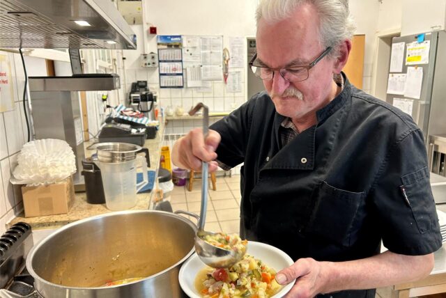 Rudi Brdnek vor einem großen Suppentopf: In der Agora-Küche gibt es Gemüsesuppe.