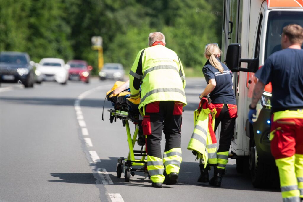 Rettungskräfte rollen eine verletzte Person auf einer Trage zum Rettungswagen. Rettungskräfte rollen eine verletzte Person auf einer Trage zum Rettungswagen.