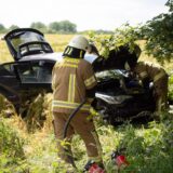 Feuerwehrleute an einem Autowrack.