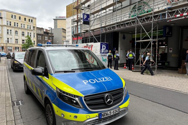 Ein Polizeiwagen steht in einer Straße vor einem Parkhaus in der Dortmunder Innenstadt.