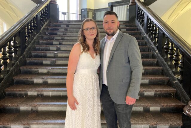 Zu sehen ist das Hochzeitspaar Dominik (28) und Melina Franz (27) vor der Treppe im Eingang des alten Dortmunder Rathauses.
