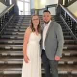 Zu sehen ist das Hochzeitspaar Dominik (28) und Melina Franz (27) vor der Treppe im Eingang des alten Dortmunder Rathauses.