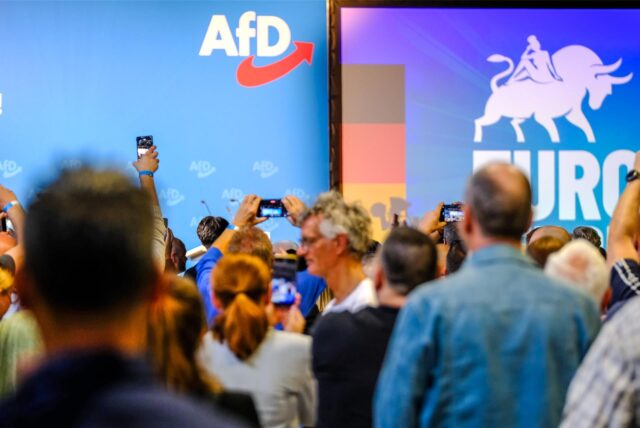 Politiker der AfD halten ihre Handys hoch.