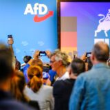 Politiker der AfD halten ihre Handys hoch.