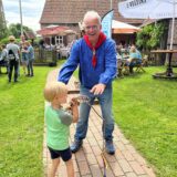 Reinhold Wieschus überreicht einem Kind ein Seil.