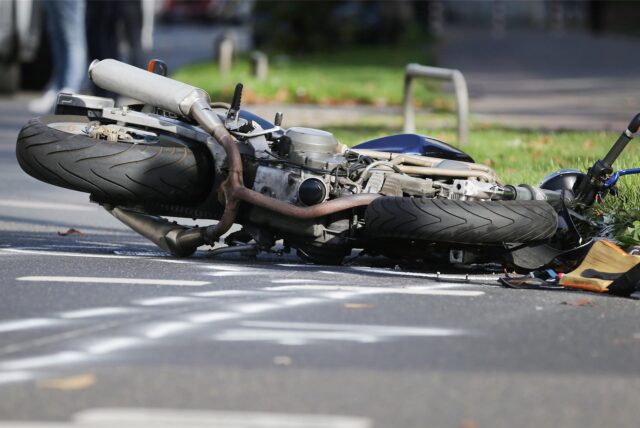 Nach einem Verkehrsunfall liegt ein demoliertes Motorrad auf der Fahrbahn. (Symbolbild)