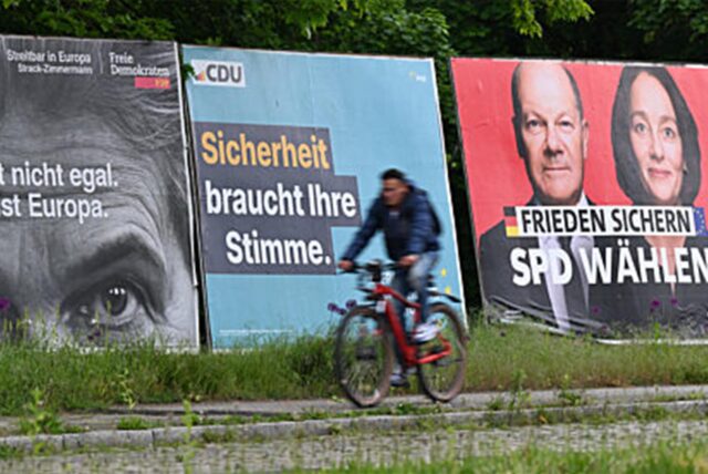 Ein Radfahrer fährt im Stadtteil Sachsenhausen an Großplakaten von FDP (l-r), CDU, SPD und Freien Wählern zur Europawahl vorbei.