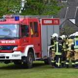 Feuerwehrleute stehen am Mannschaftswagen.