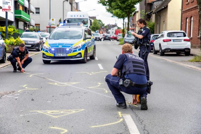 Nach einem Unfall in Herten-Langenbochum nehmen Polizisten Messungen vor. Auf der Fahrbahn haben sie zuvor die Standorte der beteiligten Pkw markiert.