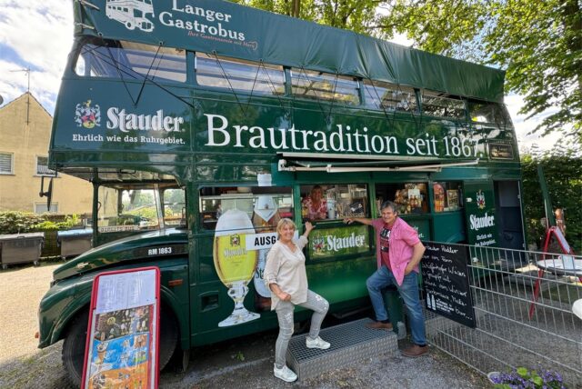 Eine Frau und ein Mann stehen vor einem Gastrobus