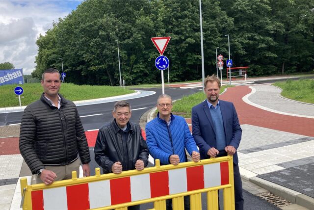 Vier Männer hinter einer Absperrung