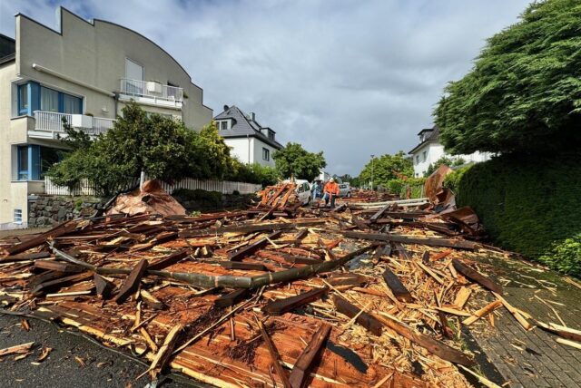 Trümmer eines Kirchturmdaches liegen auf der Straße.