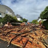 Trümmer eines Kirchturmdaches liegen auf der Straße.