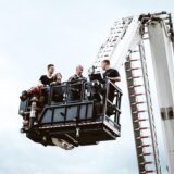 In einem Krankorb der Werkfeuerwehr stehen vier Personen.