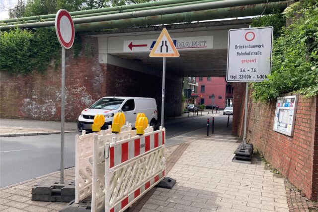 Autos fahren auf der Bahnhofsstraße in Herten-Westerholt unter der Eisenbahnbrücke hindurch.