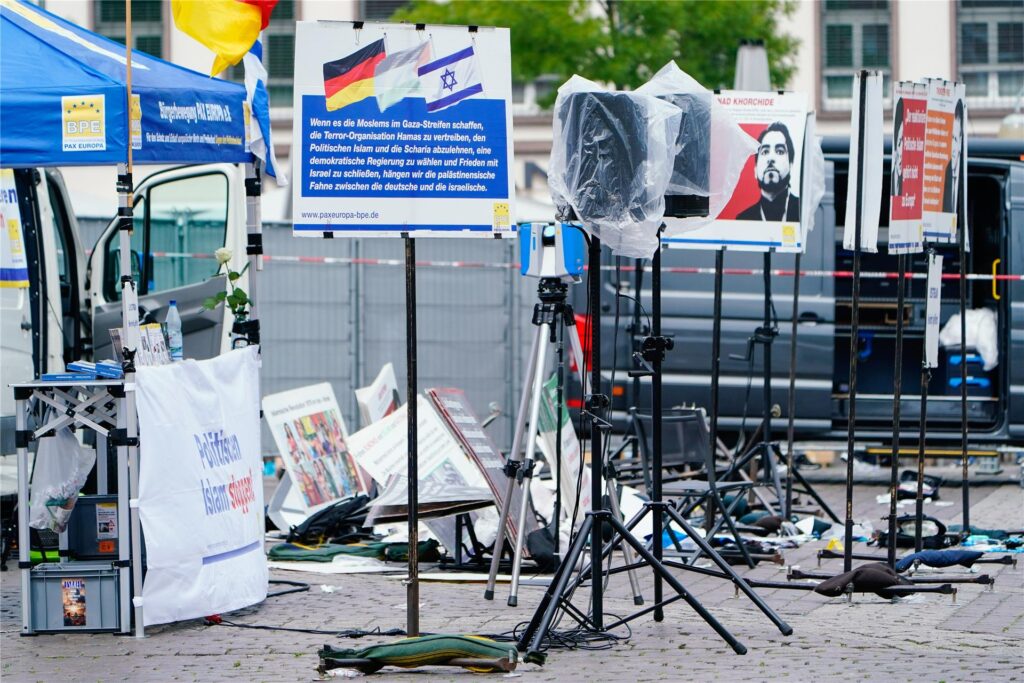 Plakate eines Standes liegen auf dem Marktplatz auf dem Boden.