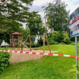 Flatterband ist vor einen Spielplatz mit Kletterturm und Schaukel gespannt.