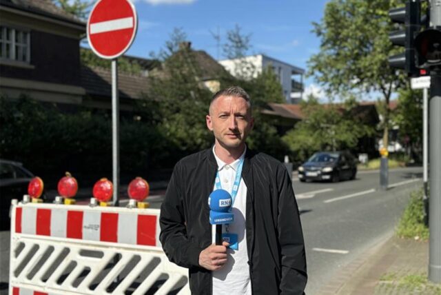 Philipp Pohl steht vor einer Baustellen-Bake.