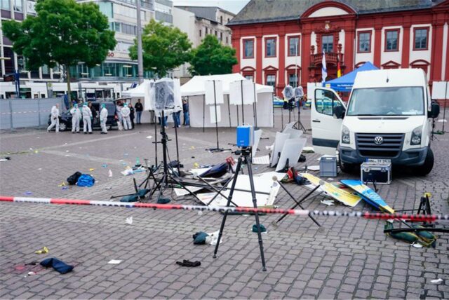 Mitarbeiter der Spurensicherung stehen auf dem Mannheimer Marktplatz hinter einem zertrümmerten Stand.