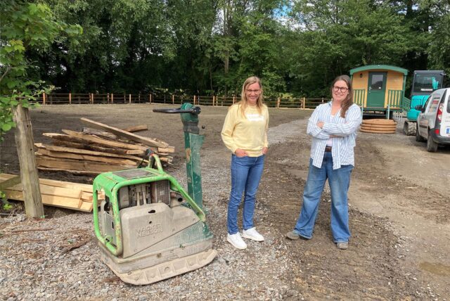 Jessica Trogant (links) und Nina Giebler, die beide dem Vorstand des Integrativen Reitvereins Ried angehören, stehen vor dem Gelände des neuen Hertener Waldkindergartens, der zu diesem Zeitpunkt noch Brachland ist.