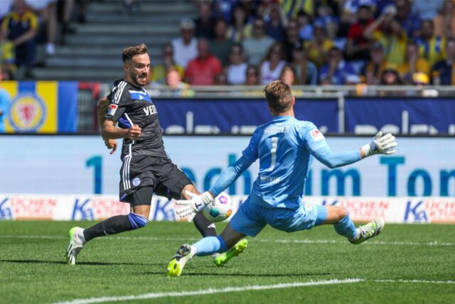 Kenan Karaman (FC Schalke 04) versucht, den Ball an Ron-Thorben Hoffmann (Eintracht Braunschweig) vorbeizuschießen.