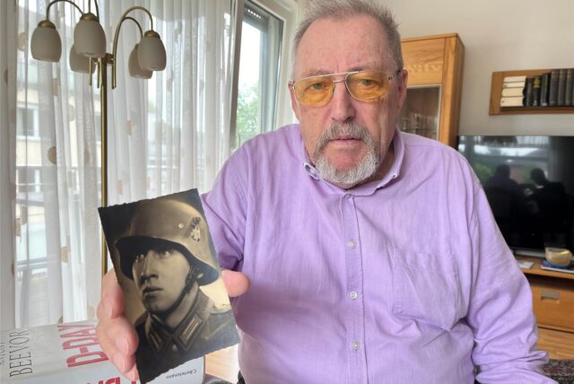 Wolfgang Guß hält ein Foto seines Vaters Franz Guß hoch.