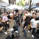 Die Musikgruppe The Servants während eines Auftritts in der Antoniusstraße, auf der viele Menschen sind, in Herten.