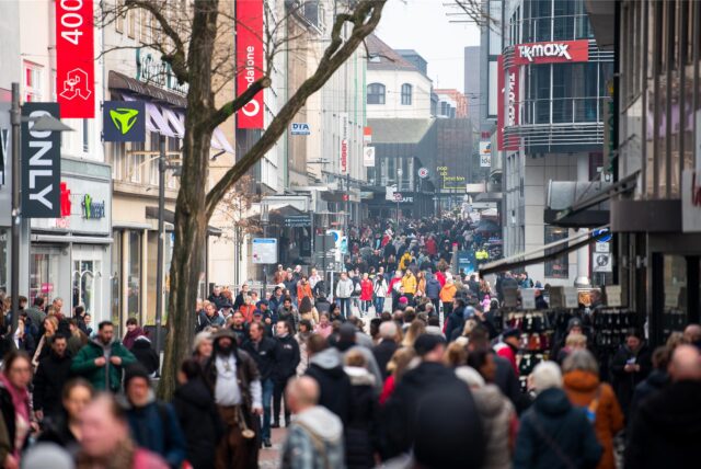 Passanten gehen während des verkaufsoffenen Sonntags durch die Innenstadt.