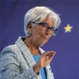 Die EZB-Chefin Christine Lagarde gestikuliert leicht mit ihrer Hand und erklärt auf einem Podium vor Journalisten ihre Entscheidung.