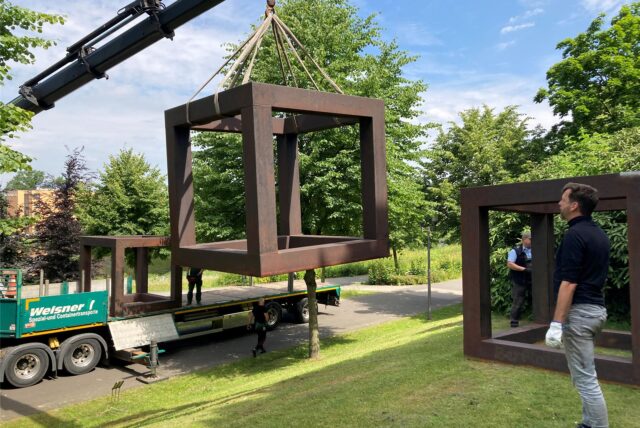 Mit einem Drehkran werden Alf Lechners insgesamt 3,5 Tonnen schwere Würfel auf die Wiese am City-See gehievt. Diplom-Restaurator Ulrich Feldhaus überwacht die Arbeiten.