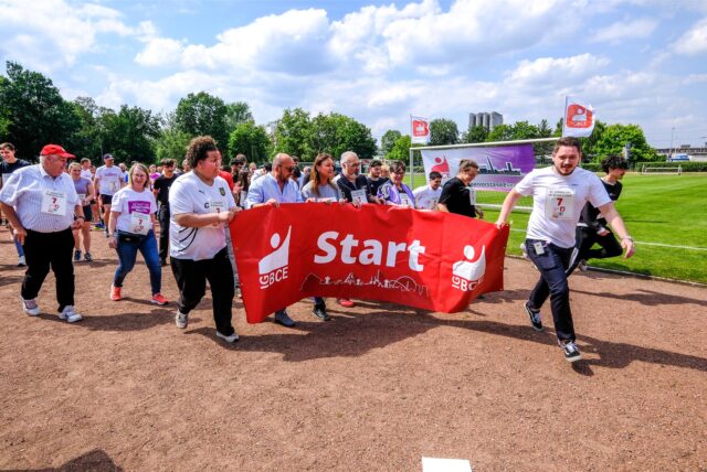 Menschen laufen mit einem Banner in der Hand.