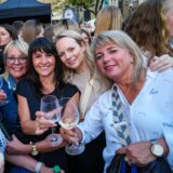 Frauen stoßen auf dem Abendmarkt in Recklinghausen mit einem Glas Wein an.