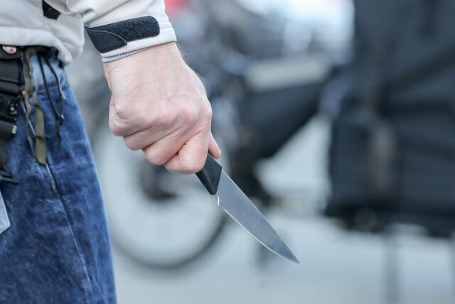 Ein Mann hält ein Messer in seiner Hand.