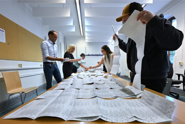 Wahlhelfer sortieren die Stimmzettel der Europawahl.