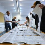 Wahlhelfer sortieren die Stimmzettel der Europawahl.