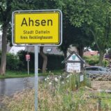 Ein Ortseingangsschild an einer Straße.