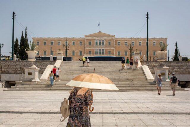 Eine Frau schützt sich mit einem Sonnenschirm auf dem Syntagma-Platz in Athen vor der Sonne: Warme Luftmassen sorgen für Temperaturen von örtlich bis zu 45 Grad.