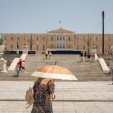 Eine Frau schützt sich mit einem Sonnenschirm auf dem Syntagma-Platz in Athen vor der Sonne: Warme Luftmassen sorgen für Temperaturen von örtlich bis zu 45 Grad.