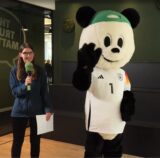 Volontärin Katharina Göke steht neben dem Panda.