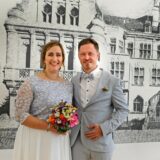 Das Brautpaar Mirja Riewe und Matthias Melaloli vor einer Abbildung des Recklinghäuser Rathauses