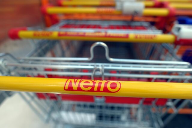 Der Schriftzug „Netto“ steht auf einem Einkaufswagen.