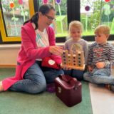 Steffi Kopper spielt auf dem Boden mit zwei Kindern.