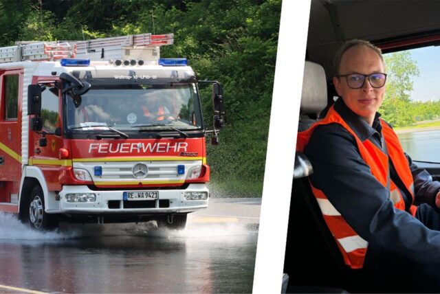 Ein Feuerwehrfahrzeug fährt auf nasser Straße, ein Mann sitzt am Steuer