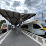 Das Gleis eines Bahnhofs ist zu sehen. Auf den Gleisen stehen Züge.