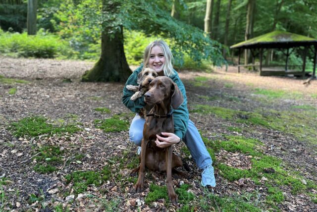 Paula mit ihren beiden Hunden im Wald.