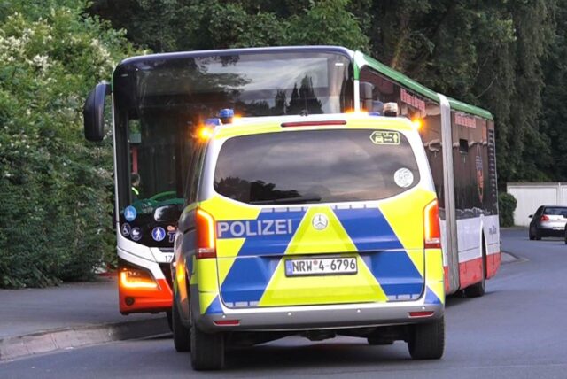 Ein Polizeiwagen steht vor einem Bus in Dortmund.