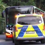 Ein Polizeiwagen steht vor einem Bus in Dortmund.
